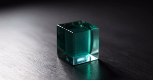 A 300 by 156 pixel heavily compressed image of a glass cube, soft and blocky
